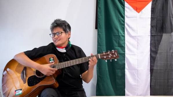 Shayan singing with an acoustic guitar